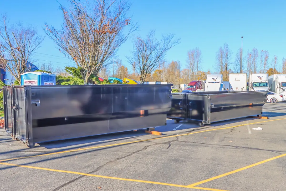 Professional dumpster rental service with roll-off container on residential driveway in East Niles